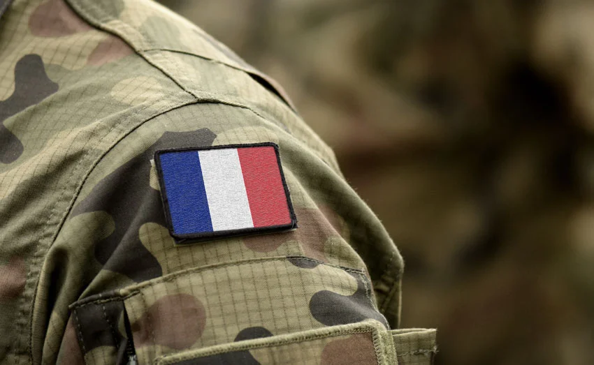 Un écusson du drapeau français sur la manche d'un uniforme militaire de camouflage
